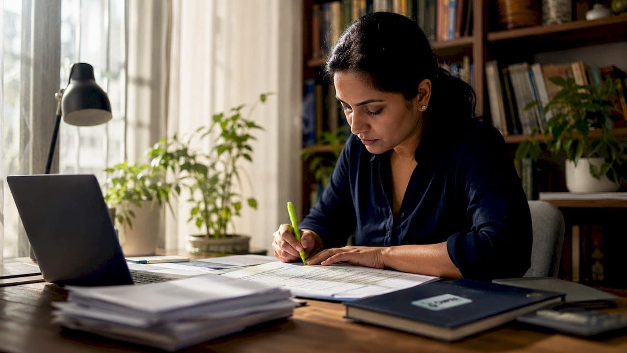 Accountant reviewing payroll reconciliation reports at desk